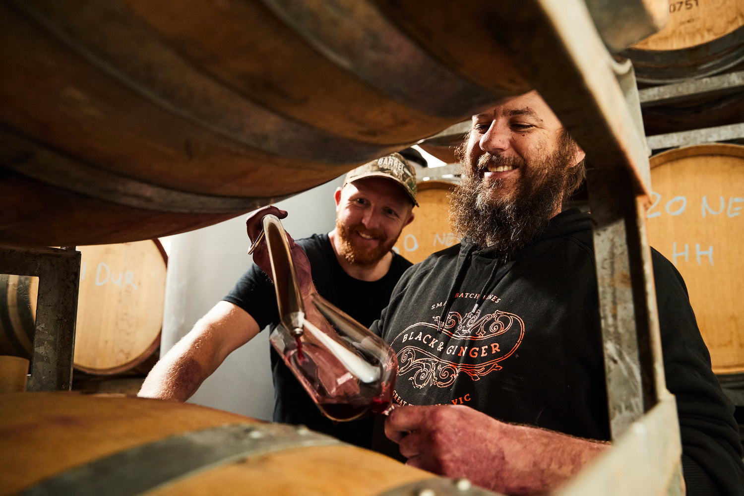 Hadyn and Darcy sampling barrels in the winery