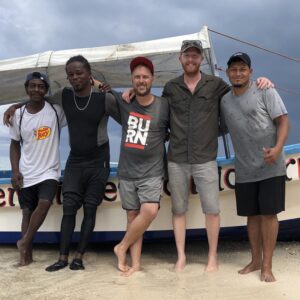 Hadyn and Darcy with a fishing boat in Belize in 2019