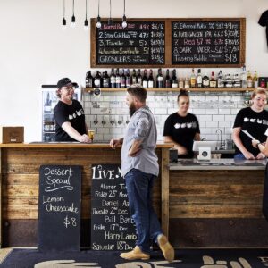 Hadyn standing at the bar delivering wine at Paper Scissors Rock Brewery in Halls Gap
