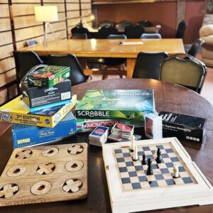 A stack of boardgames on a table in the wine shed 