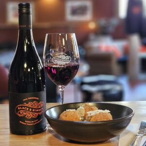 A glass of Persephone, House Red, served with Arancini at the Black & Ginger Wine shed